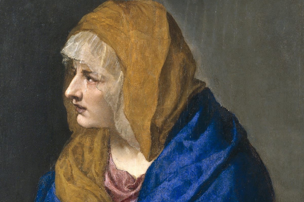 A three-quarter portrait of the Blessed Virgin Mary, head covered in an amber veil over a white underveil and a dark blue mantle, weeping with her eyes turned upward and to the side, a tear on her cheek.