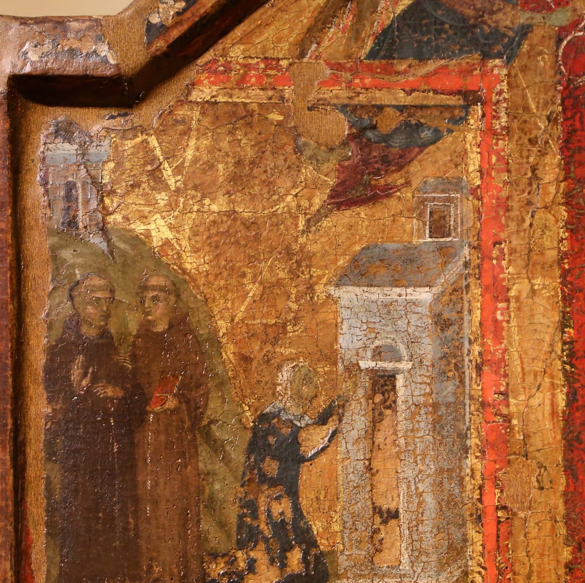 A tempera panel on a gold ground showing a haloed woman kneeling before a church door, two cowled friars standing at left, and the roofs of Cortona behind.