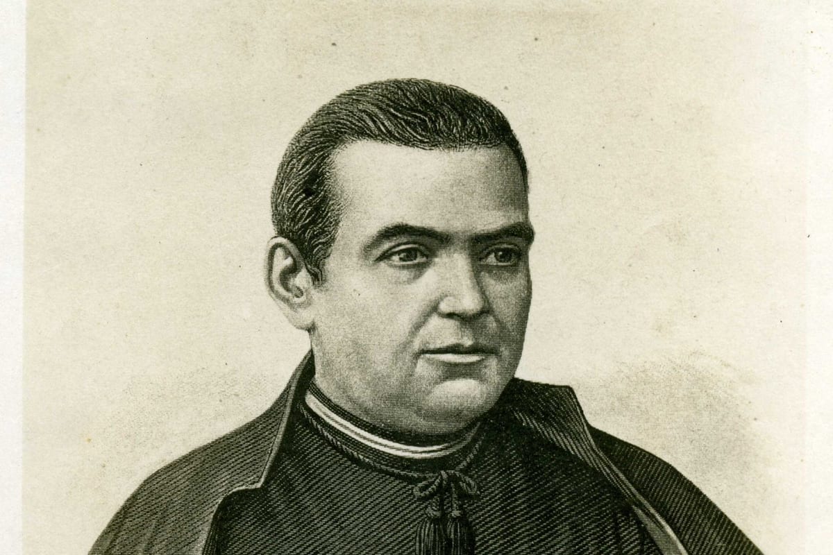 An engraved portrait of a young Catholic priest with short dark hair, shown head and shoulders, wearing a cassock and cape with a clerical collar, looking slightly to the side.