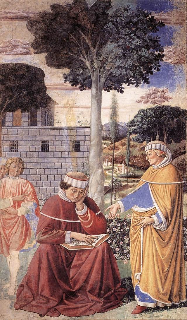 A young man sits under a fig tree with an open codex on his knee and a friend beside him.