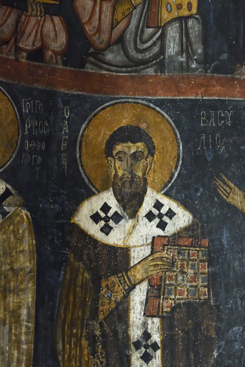 In a rock-cut church at Gumusler in Cappadocia, Saint Basil stands vested and named in the lowest band of the apse beside Saint Gregory of Nyssa and Saint Gregory of Nazianzus.
