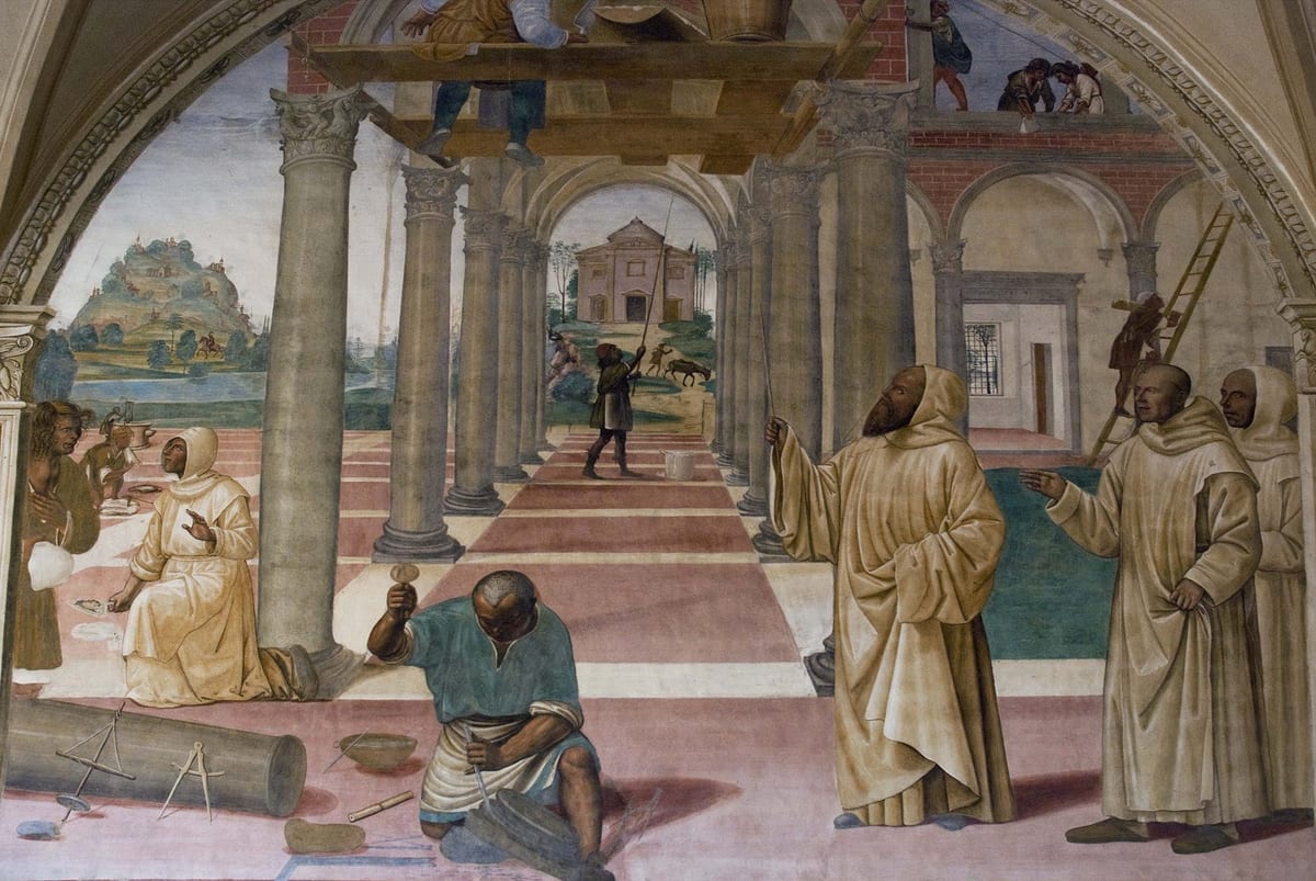 A bearded, hooded Benedictine abbot gestures toward a group of monks under a colonnade as workmen build a monastery in the background, in a Renaissance fresco depicting Saint Benedict founding his twelve monasteries.