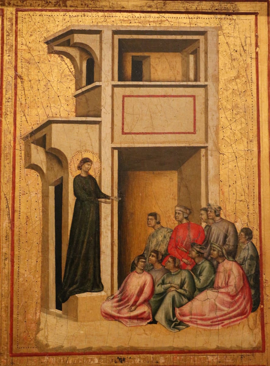 A haloed Saint Cecilia in a dark green robe stands in an arched doorway, one hand extended, preaching to a seated group of men and women in pink, red and grey robes gathered before her, in a gold-ground panel painting of arched Gothic architecture.