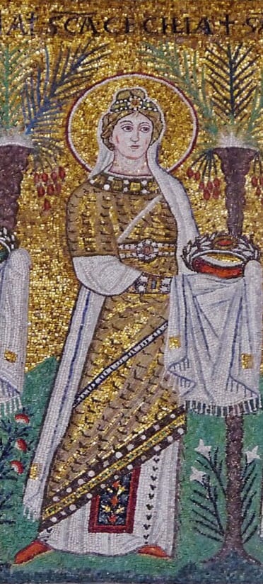 Saint Cecilia stands frontally in the file of virgin martyrs in a white and gold court dalmatic with a jewelled border and a white veil, carrying the crown of martyrdom in veiled hands with her name lettered above her.