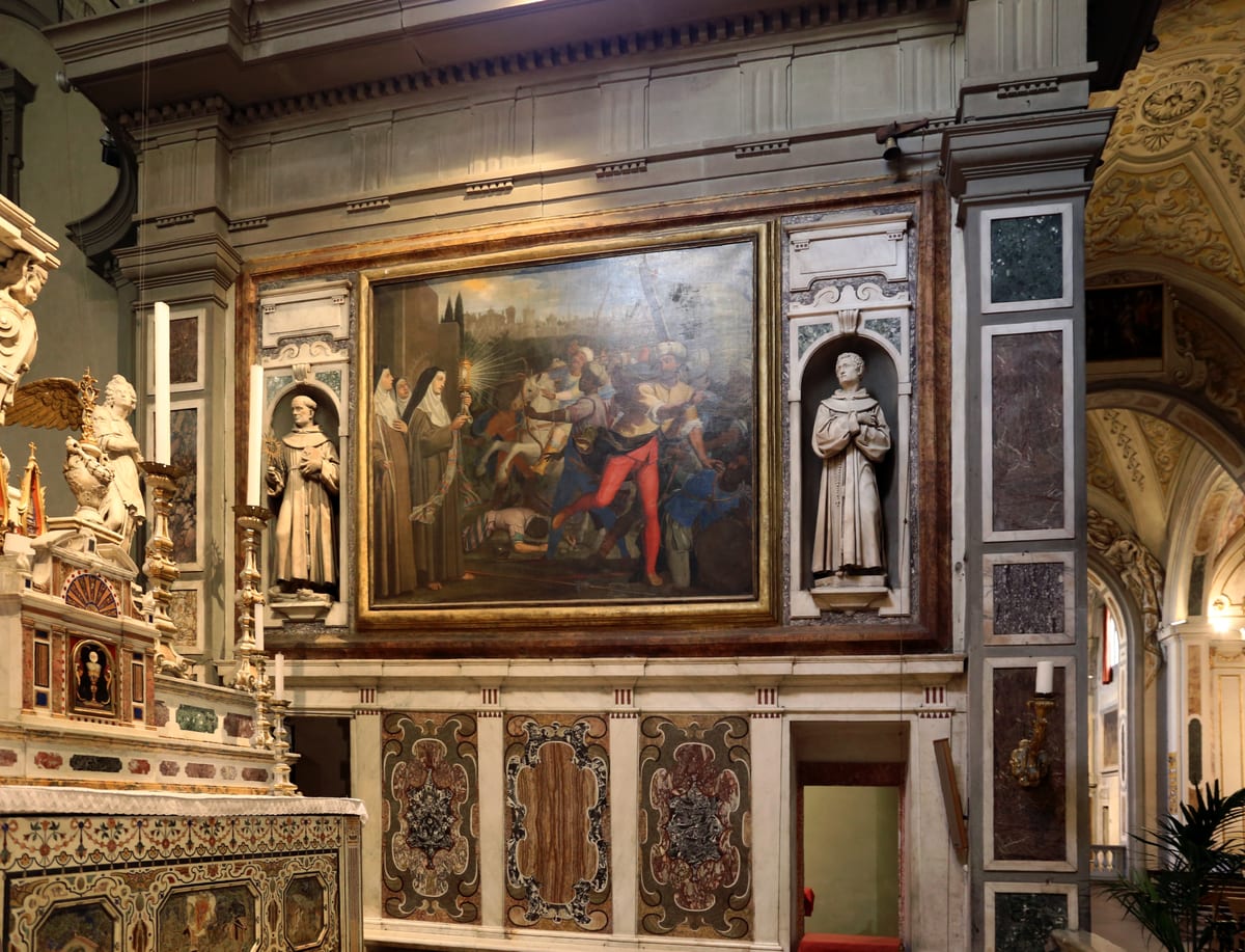 A painting of St. Clare kneeling low and small at the monastery threshold with the Blessed Sacrament, her sisters gathered behind her, as soldiers on ladders above turn away.