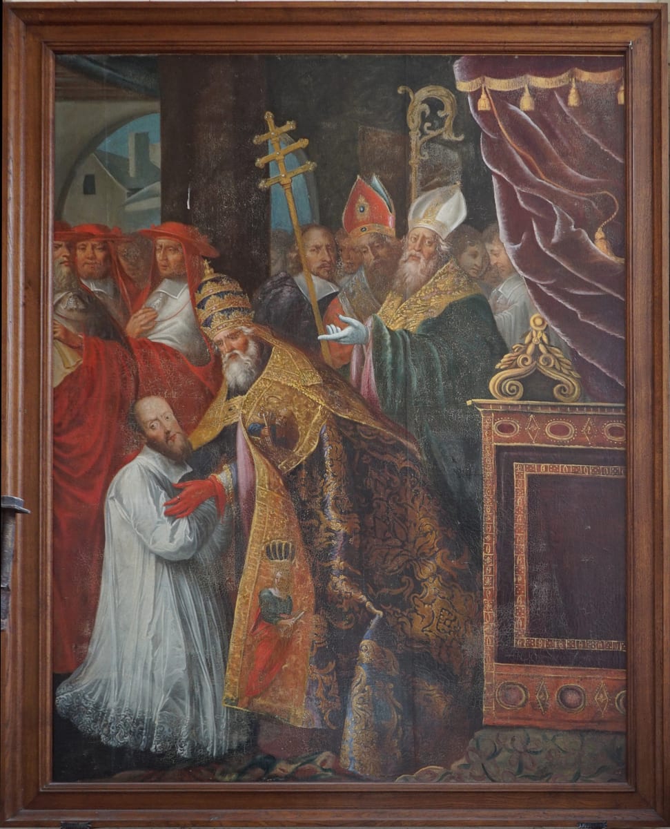 An oil painting shows Pope Clement VIII, in a tiara and gold brocade cope, embracing the kneeling bishop-elect in a white lace surplice, with cardinals and mitred bishops gathered around them.