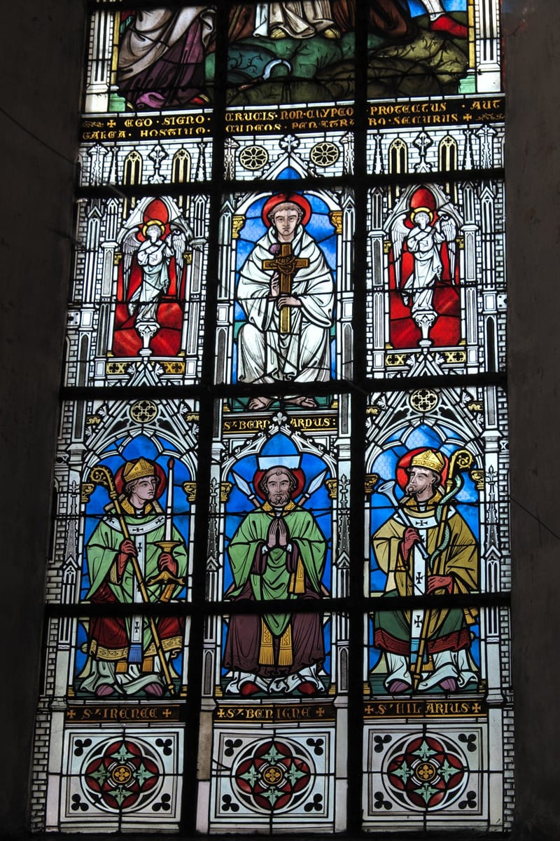 A four-light stained-glass window places St. Irenaeus, in bishop's vestments and holding a book, beside St. Bernard of Clairvaux, St. Benignus of Dijon and St. Hilary of Poitiers.