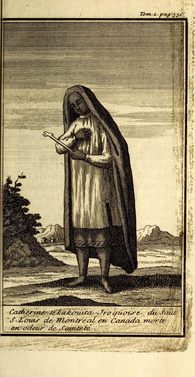 An engraving of a young woman standing on a low rise, head bent, a long dark mantle drawn over her head and her right hand flat on her breast.