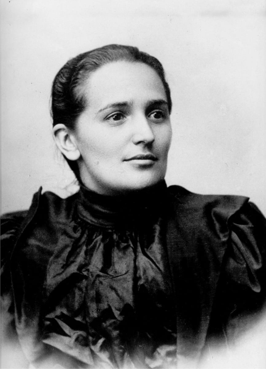 A young Laura Montoya, around the time of her teaching years before her 1914 departure for Dabeiba, in a studio portrait wearing a high-collared dark dress, her hair pulled back, looking off to one side.