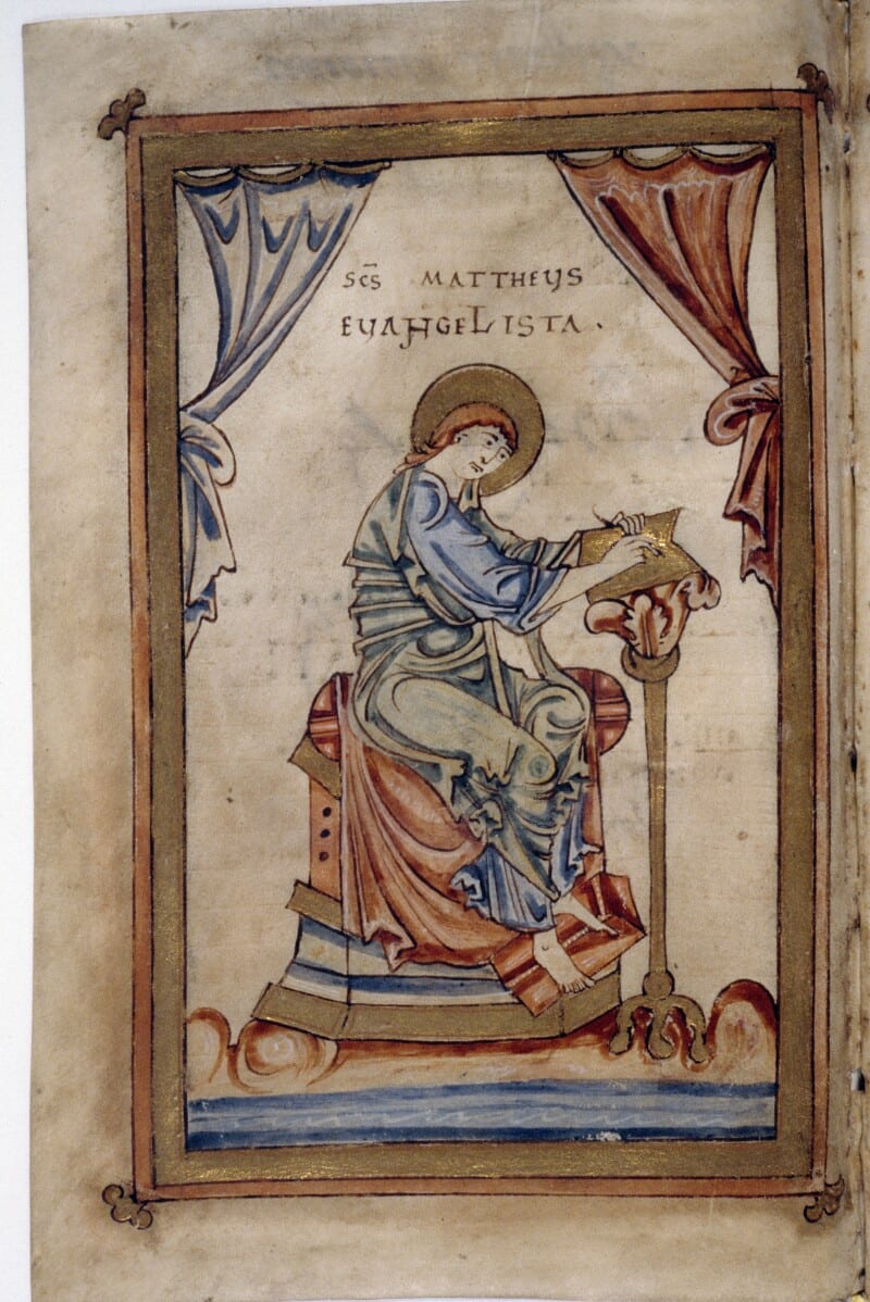 A full-page miniature shows the haloed St. Matthew writing at a slender lectern beneath looped blue and red curtains inside a gold frame.