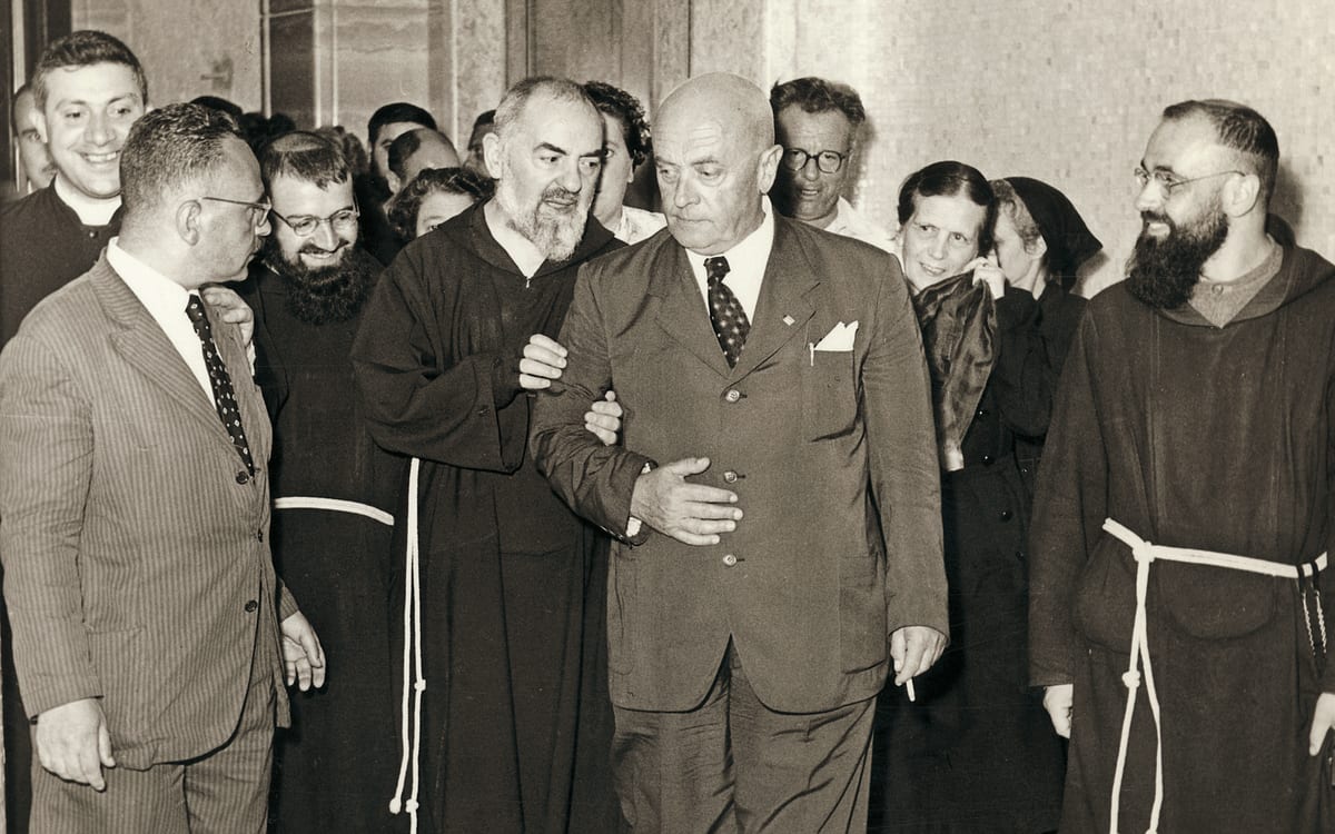 A photograph of St. Pio walking along a hospital corridor with Dr. Guglielmo Sanguinetti.