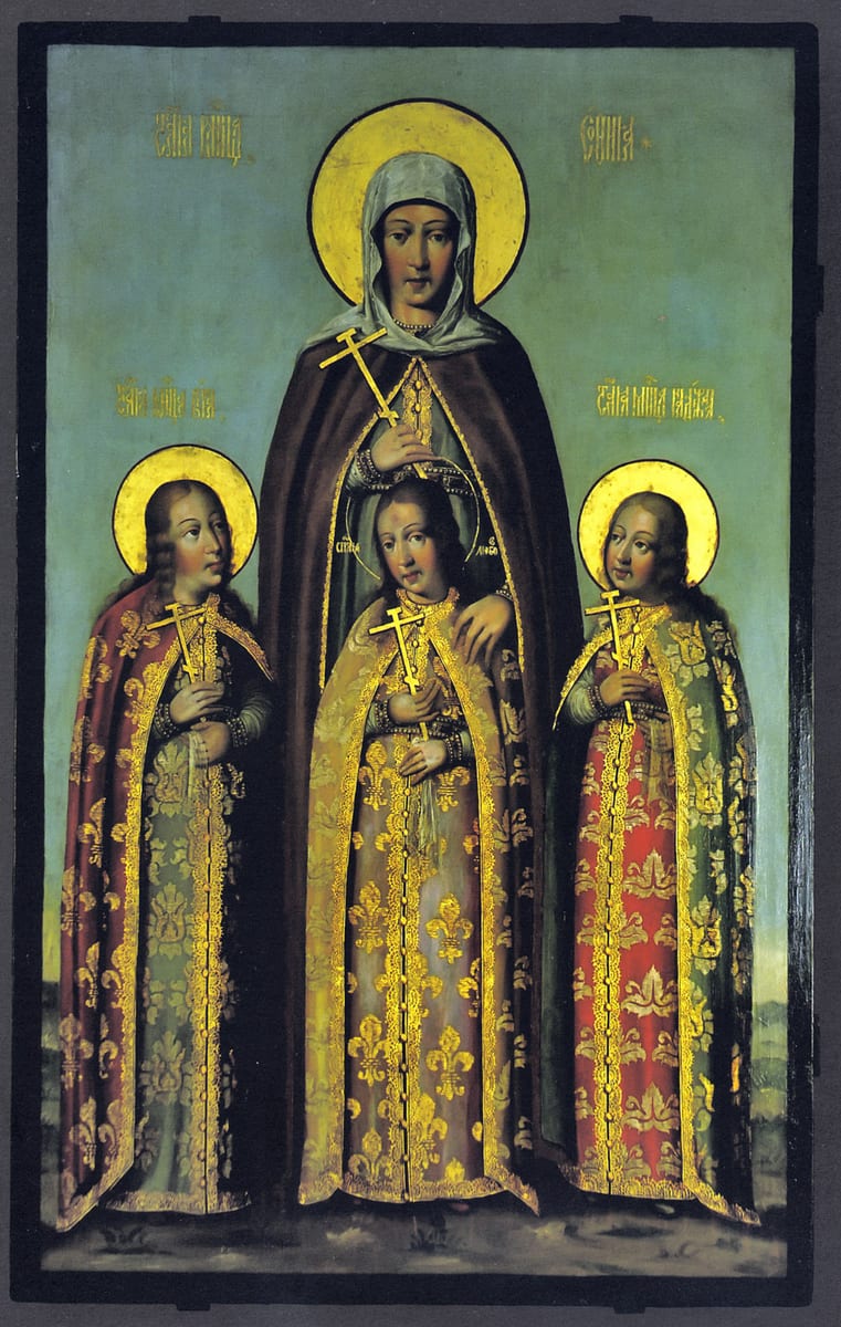A Russian icon shows St. Sophia in a brown mantle and white veil, a cross in her hand, standing behind her three haloed daughters, each in a brocade cloak and holding a cross, her hand resting on the middle girl's shoulder.