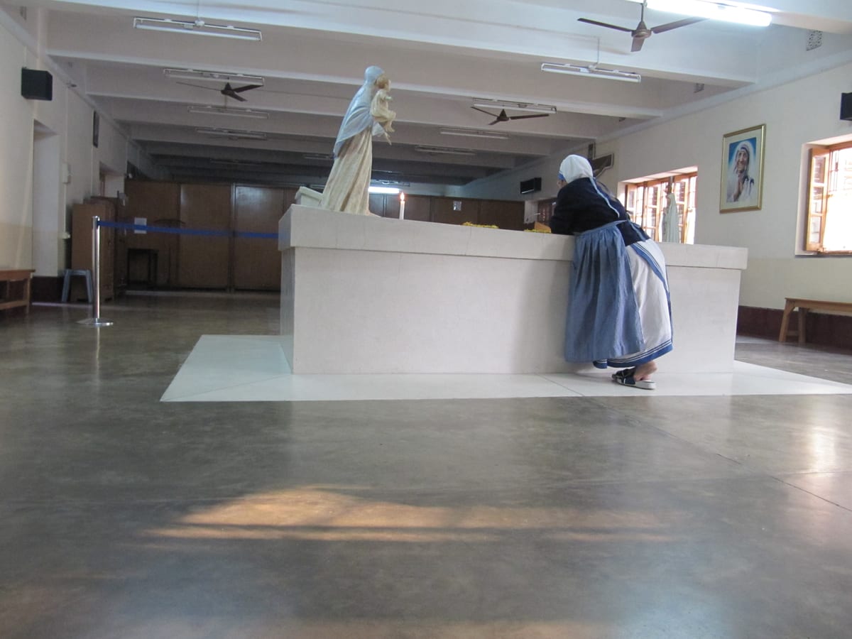 A sister arranges flowers on the tomb at the Mother House in Calcutta, photographed in January 2012 AD.