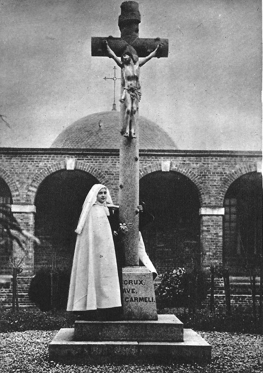 St. Thérèse as a novice in the white veil, standing at the calvary in the courtyard of the Carmel of Lisieux in January 1889 AD, a few days after she received the habit.