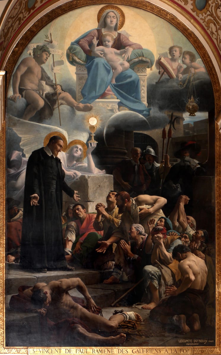 Saint Vincent de Paul stands among convicts in the dungeon of the galleys.